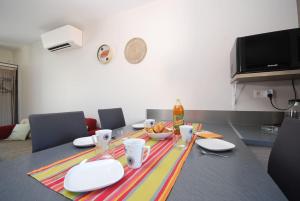 una mesa de comedor con platos y tazones de comida. en Maison Le Montadou avec Roof Top by Keskeyspass, en Cuxac-dʼAude
