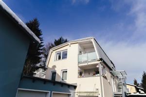 a white building with a balcony on top of it at Stadtapartment KUS in Klagenfurt