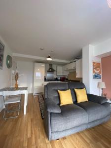 uma sala de estar com um sofá cinzento e uma mesa em Beautiful 1 -Bed Apartment in Ferry Village/Renfrew em Renfrew