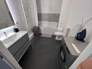a bathroom with a sink and a washing machine at Appartement proche Paris, C DG, Disney, Parking. in Aulnay-sous-Bois