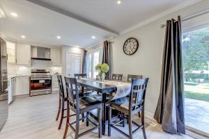 a kitchen with a table and chairs and a clock on the wall at Stunning 7 Br House with 2-Kitchen, 5-Washroom & Amazing Backyard in Toronto