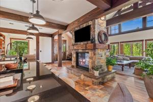 a living room with a stone fireplace and a tv at Sugarloaf Summit Rare Tamarack Ski Inout Estate in Donnelly