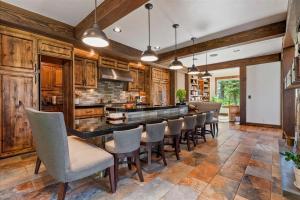 a kitchen with wooden cabinets and a bar with chairs at Sugarloaf Summit Rare Tamarack Ski Inout Estate in Donnelly