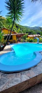 une grande piscine bleue dans un complexe dans l'établissement Recanto Casa Amarela de São Romão, à Nova Friburgo