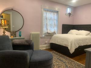 a bedroom with a bed and a chair and a mirror at Oak Park Beauties - Tree Lined Streets - Walkable in Oak Park