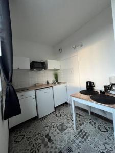 una pequeña cocina con fregadero y mesa en Charmant T1, parking privé, proche gare, en Moulins