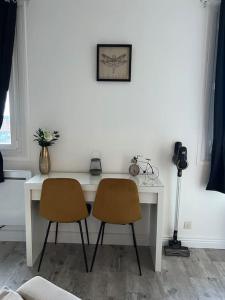 - Escritorio blanco con 2 sillas en una habitación en Charmant T1, parking privé, proche gare, en Moulins
