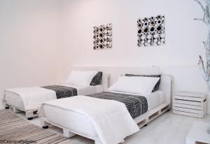 two beds in a room with white walls at B&B Stazione in Floridia