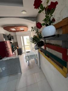 ein Wohnzimmer mit einer Vase an einer Wand mit Rosen in der Unterkunft Appart S plus 2 à Sousse zone touristique in Sousse