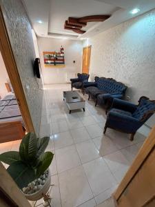 una sala de estar con sofás y sillas. en Appart S plus 2 à Sousse zone touristique en Sousse