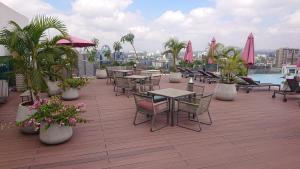 a patio with tables and chairs on a roof at Luxury Skynest with Gym and Pool in Westlands in Nairobi