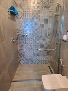 uma casa de banho com um chuveiro, um WC e um lavatório. em Luxury Skynest with Gym and Pool in Westlands em Nairobi