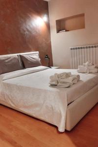 a bed with white sheets and towels on it at Sapori e Sapere di Troisi Margherita in Sicignano degli Alburni