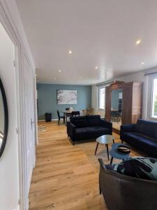 a living room with couches and a dining room at La Villa Voie Verte in Riorges
