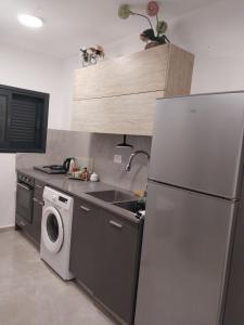 a kitchen with a refrigerator and a washing machine at שירת דבורה בבני ברק in Giv‘at Shemuʼel