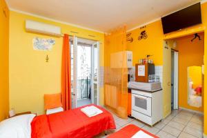 żółty pokój z łóżkiem i kuchnią w obiekcie Grotta dello Sport w Turynie