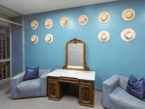 pared azul con espejo, 2 sillas y mesa en Low Cost Business Hotel, en Piura