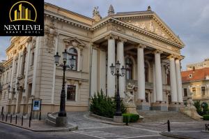 ein Gebäude mit Säulen und einer Straßenlaterne davor in der Unterkunft NEXT LEVEL Apart in Oradea