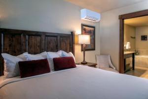 1 dormitorio con 1 cama blanca grande con almohadas rojas en Grand Lodge on Peak 7 en Breckenridge