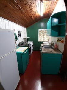 een keuken met groene kasten en een witte koelkast bij Casa céntrica in Oberá