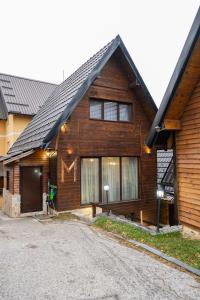 a wooden house with a driveway in front of it at Villa Zagorka and mountain houses A, M, D in Kopaonik