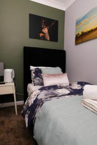 a bedroom with a bed with a deer picture on the wall at Home at Richmond - Serenity Suite in Nottingham