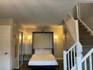 a bedroom with a bed and a staircase at Blue Mountain 2 Story Studio Loft in Blue Mountains