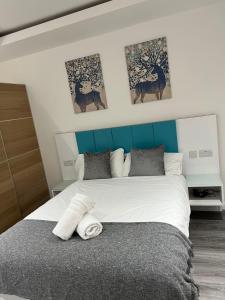 a bedroom with a large bed with a blue headboard at Crosskeys Edinburgh in Edinburgh