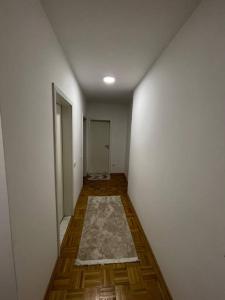 an empty hallway with a white wall and a rug at Apartment in Gjilan in Gnjilane