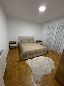 a bedroom with a bed and a rug at Apartment in Gjilan in Gnjilane