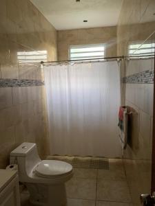 a bathroom with a toilet and a shower curtain at Million dollar view in Puerto Rico in Luquillo