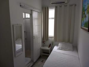 Dormitorio pequeño con cama y espejo en Hotel Marajoara, en Belém
