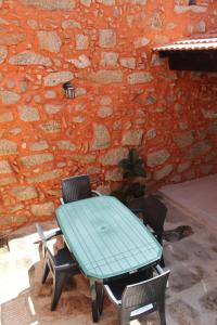 a blue table and chairs in front of a brick wall at Casa da Avó Carriça in Santar