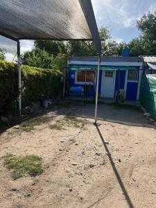 una tienda frente a una casa azul en La Pintada Economy Class en Villa Dolores