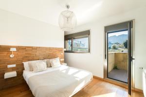 Un dormitorio con una cama grande y una ventana en helloasturias, Casa en Llanes con piscina, jardín, cerca de la playa. en Llanes