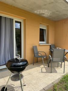 - un barbecue sur une terrasse avec des chaises et une table dans l'établissement L'évasion verte, à Langres
