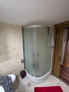 a bathroom with a glass shower and a toilet at Harika ev aileler için in Konak