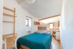 a small bedroom with a blue bed and a kitchen at Le ciel du Palais - Intramuros - 2 ch - Wifi in Avignon