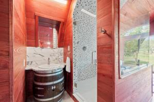 a bathroom with a barrel sink and a shower at Unique Tempranillo Wine Barrel Cabin in Fredericksburg