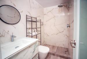 een witte badkamer met een wastafel en een toilet bij Paradise Coast PR - Condo in Isabela