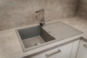 a kitchen sink with a faucet on a counter at Old Town city center apartment 2 - private parking included in Košice