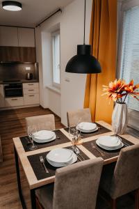 a dining room table with chairs and a vase of flowers at Old Town city center apartment 2 - private parking included in Košice