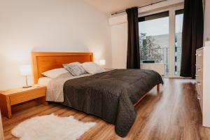 a bedroom with a bed and a large window at Old Town city center apartment 2 - private parking included in Košice