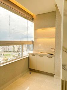 a kitchen with a large window with a view of a city at Apto Moderno c/ Vista Fantástica do Flamboyant in Goiânia