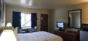 a hotel room with a bed and a television at Orland Inn in Orland