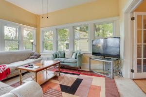 a living room with a couch and a flat screen tv at Eau Claire Retreat Close to Chippewa Riverfront! in Eau Claire