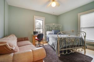 1 dormitorio con 1 cama y 1 sofá en Eau Claire Retreat Close to Chippewa Riverfront! en Eau Claire