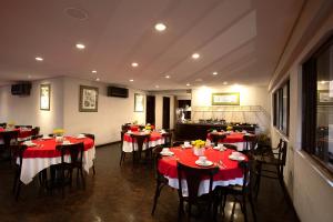 a dining room with red and white tables and chairs at Rede Andrade São Francisco in Curitiba