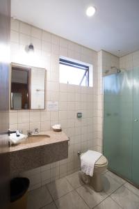 a bathroom with a shower and a toilet and a sink at Rede Andrade São Francisco in Curitiba