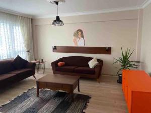 een woonkamer met een bank en een salontafel bij Ferah ve şık cosy daire in Konak